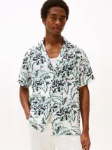 Camisa de manga corta con cuello solapa y estampado floral en tonos negro, blanco y verde.