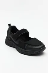 Zapatilla negra con tira ajustable y velcro.