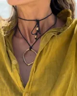 Collar con dije circular irregular de alpaca y plata 925, con hilo de algodón natural.