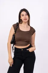 Remera negra de corte crop con escote redondo y mangas cortas. Presenta cordones ajustables en los laterales.