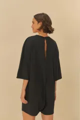 Mono corto negro con estampado de un tucán dentro de un círculo con hojas.