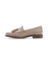 Mocasín de cuero color beige, con borlas ornamentales y puntadas artesanales.