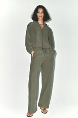 Pantalón verde oliva de tiro alto con bolsillos delanteros y traseros. Cintura elástica ajustable con cordones y pierna ancha.