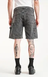 Bermuda de denim gris con efecto lavado, calce oversize estilo carpintero y bolsillo lateral.