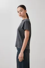 Remera rosa pastel de manga corta con tachas plateadas en los hombros.