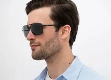 Lentes de sol INVU modelo B1007A, con montura metálica negra, lentes polarizadas grises y forma aviador.