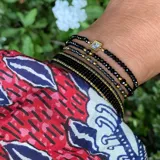 Pulsera elástica con cuentas de piedra natural espinela negra, cuentas alternadas goldfilled y dije cuadrado con cristal y acero.