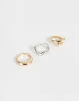 Set de tres anillos de metal con diferentes diseños chunky, uno dorado liso, uno plateado con forma irregular y uno dorado con forma de espiral.