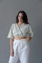 Top cruzado escotado de tusor de algodón con estampado de lunares verdes, cintura elastizada y manga corta holgada.