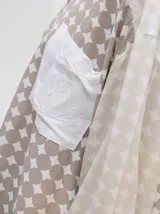 Camisa de manga larga con estampado geométrico de círculos y rombos en tonos naranja y verde, cuello camisero y bolsillo de parche en el pecho con logo bordado.