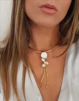 Gargantilla dorada con dije de perlas irregulares y colgantes de hilo dorado.