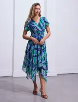 Vestido midi de gasa estampada con motivos florales en tonos azules y verdes. Escote en V tanto en la parte delantera como en la espalda. Corte en la cintura con punto smock y ruedo asimétrico.