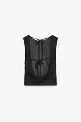 Top negro de cuello redondo y tirantes anchos. Detalle de escote en espalda con tira cruzada ajustable con lazada.