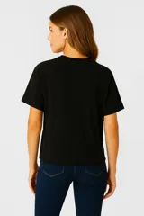 Remera blanca de corte holgado con estampado de flores negras.