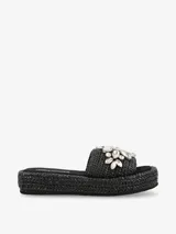 Sandalia tipo plataforma color negro con base de acabado trenzado y capellada ancha decorada con apliques de diseño floral.