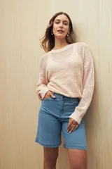 Bermuda de denim azul oscuro, de tiro alto y largo a la rodilla. Presenta bolsillos funcionales y costuras marcadas.