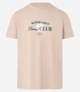 Remera color arena de algodón, con cuello redondo y mangas cortas. Estampa frontal con el texto "Monte Carlo Tennis Club" en color verde.