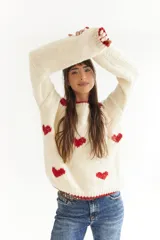 Sweater color crema de lana merino, tejido a mano, con corazones rojos.