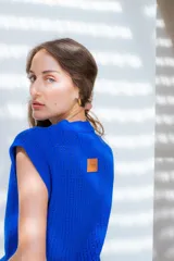 Chaleco tejido calado color naranja con mini hombreras y diseño versátil.