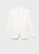 Traje sastrero blanco de tres piezas, compuesto por blazer con solapas de muesca y cierre de un botón, chaleco con escote cuadrado y doble botonadura, y pantalón de corte recto y bota ancha.