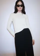 Camiseta blanca de tejido fluido con cuello redondo, capucha y mangas largas.