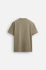 Camiseta color caqui de corte cuadrado, confeccionada en tejido de algodón pesado. Tiene cuello redondo y mangas cortas.