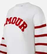Suéter blanco de jacquard con letras 'Amour' en rojo y rayas horizontales rojas en las mangas.