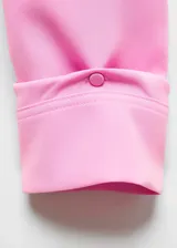 Blazer rosa con solapas de muesca, cierre con dos botones y mangas largas con puños abotonados.