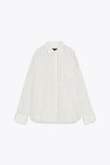 Camisa de manga larga con cuello solapa, a rayas verticales grises y blancas. Tiene un bolsillo de plastrón en el delantero y cierre frontal con botones.