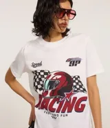 Remera blanca de algodón con cuello redondo y mangas cortas. Estampa frontal con diseño de casco de carreras, bandera a cuadros y texto "Racing Fast and Fun".