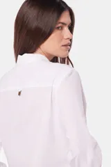 Camisa blanca de lino lisa, de manga larga con botones metálicos personalizados, dos bolsillos en el pecho y presilla en manga.
