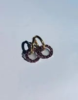 Par de aros colgantes con argollas doradas y dijes circulares de resina transparente con incrustaciones de strass de colores. El dije mide aproximadamente 1.5cm de diámetro.