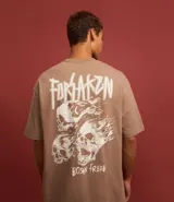 Remera marrón de algodón con efecto desteñido, corte relajado, cuello redondo, mangas cortas y estampa de calaveras con texto "Forsaken Born Freak".