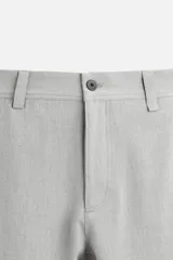 Pantalón slim fit negro confeccionado en tejido con elasticidad en ambas direcciones. Cuenta con bolsillos frontales y traseros de vivo con botón. Cierre frontal con cremallera y botón.