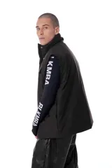 Chaleco negro con estampado de logos, cierre desmontable, broches snap ocultos, bolsillos frontales, elástico con tanca en la cintura e interior de tafeta relleno de guata.