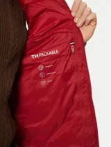 Chaleco rojo Tommy Hilfiger plegable, con cuello chimenea, cierre de cremallera, dos bolsillos laterales con cremallera y logo bordado en el pecho. Confeccionado en tejido de nailon que repele el agua.