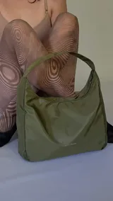 Cartera tipo baguette negra de lona semi impermeable con cierre metálico y forrería de gross con bolsillo interno.