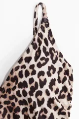 Traje de baño enterizo con estampado animal print de leopardo, escote en V, tirantes finos ajustables, copas con relleno extraíble, espalda baja y cordones laterales para fruncir.