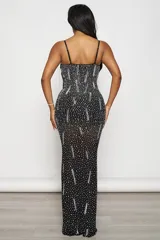 Vestido largo de fiesta negro, corte sirena, con escote en V profundo y breteles finos regulables. Confeccionado en tul elastizado con forro interior y aplique de tul transparente en el escote. Decorado con strass plateados y tornasolados.