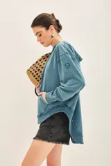 Buzo oversize color celeste de rústico de algodón con capucha forrada y terminaciones al corte.