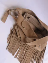 Bandolera de cuero color tostado, con flecos largos, tachas plateadas y correa regulable.