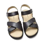 Sandalias bajas de cuero sintético negro con ajuste de velcro en el tobillo y en el empeine.