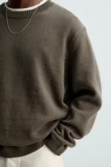 Jersey negro de corte boxy fit, tejido en hilatura con mezcla de algodón y 13% de cashmere. Tiene cuello redondo, manga larga y acabados en rib.