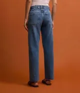 Pantalón de jean de corte recto, color azul, con tiro alto, bolsillos delanteros y traseros, cierre con botón y cremallera, y bajo a hilo.