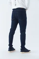 Pantalón de jean gris oscuro, corte carrot, tiro medio, con logo bordado y presillas para cinturón.