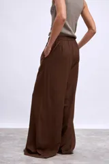 Pantalón palazzo marrón de tiro alto con cintura elastizada y cordón ajustable.