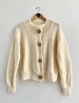 Cárdigan color crema de lana tejida con cuello redondo y botones de madera.