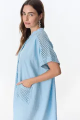 Vestido camisero celeste de lino con cuello mao, manga corta con detalle de calado y bolsillo de crochet.