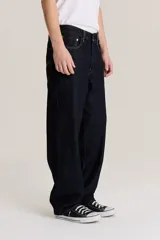Pantalón de jean azul oscuro, corte amplio, con bolsillos delanteros y traseros.