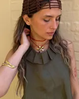 Collar artesanal con dije de flor plateada, realizado con hilo de seda natural teñido a mano.